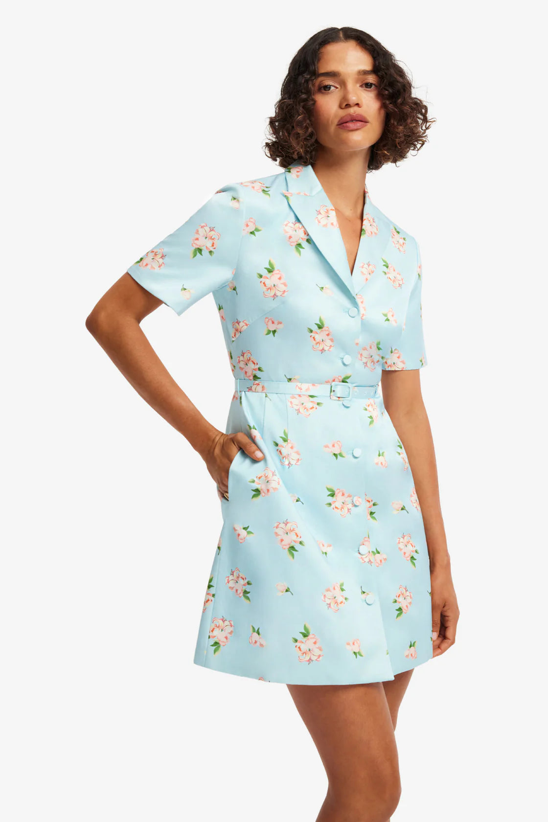 Woman wearing a light blue floral dress on a white background