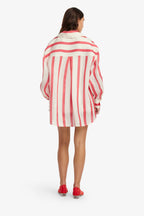 Woman wearing a red and white striped shirt dress on a white background