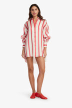 Woman wearing a red and white striped shirt dress on a white background