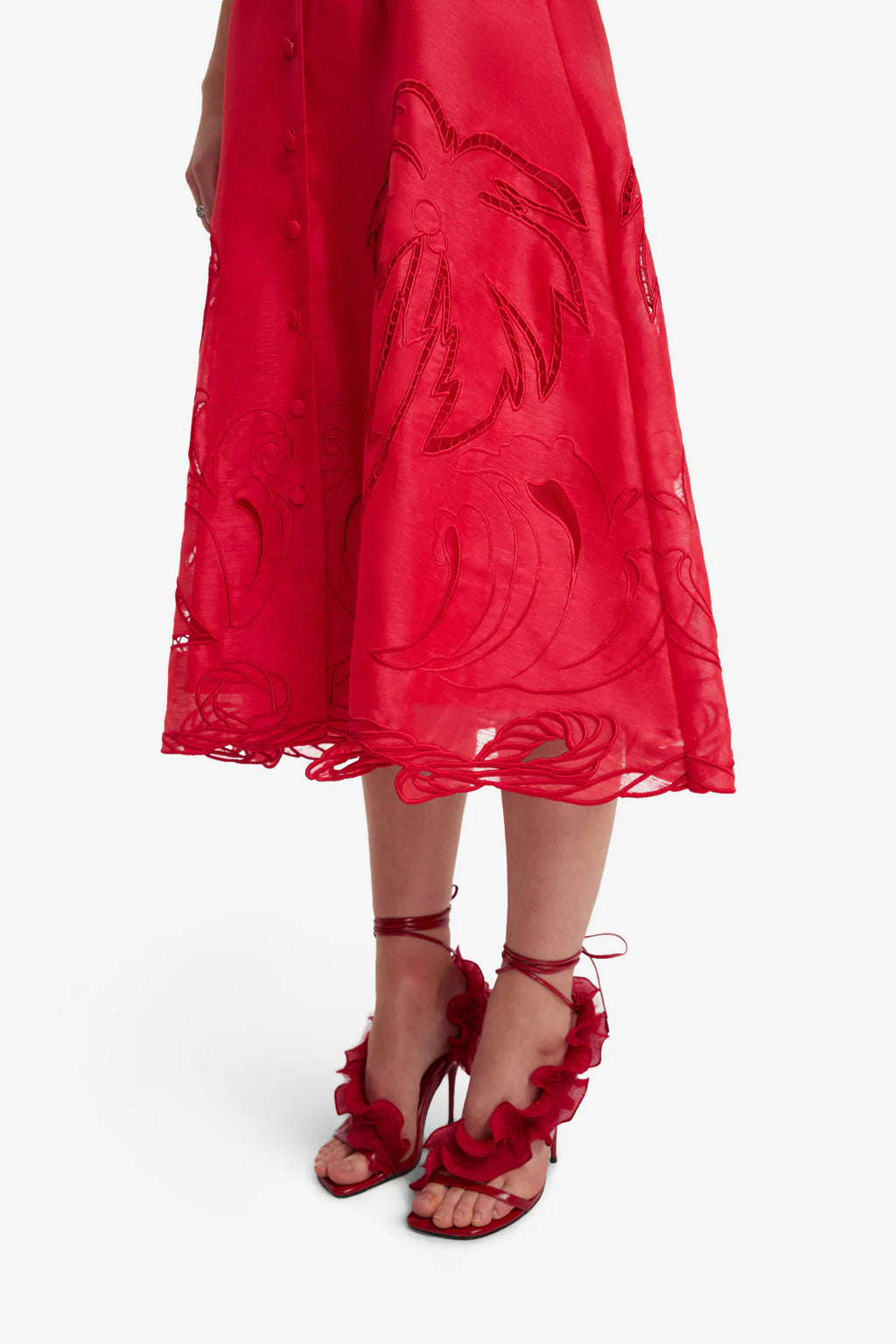 Red dress with floral embroidery and matching red sandals on a white background