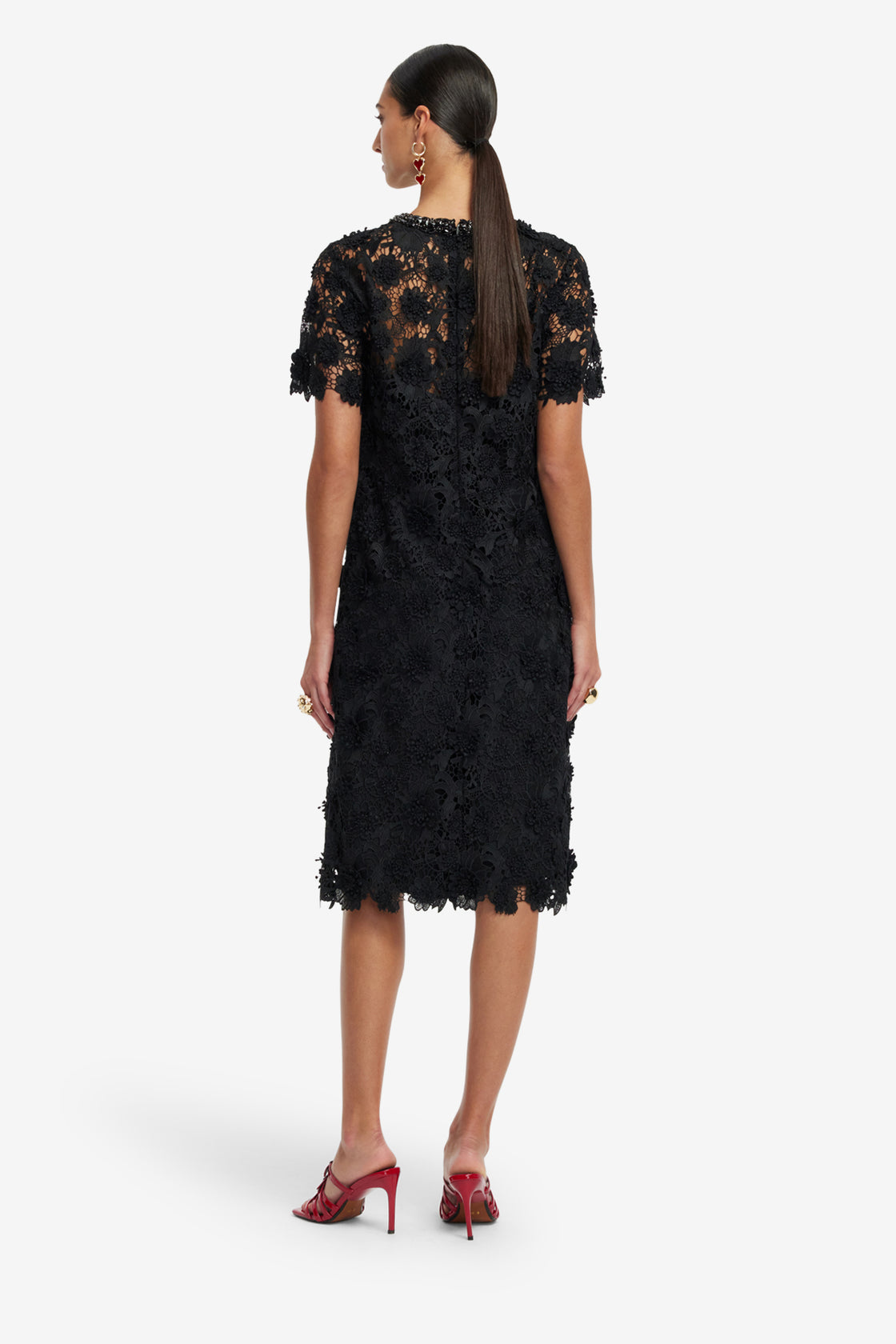Woman wearing a black lace dress on a white background