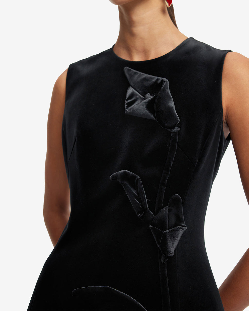 Black dress with velvet bow details on a neutral background