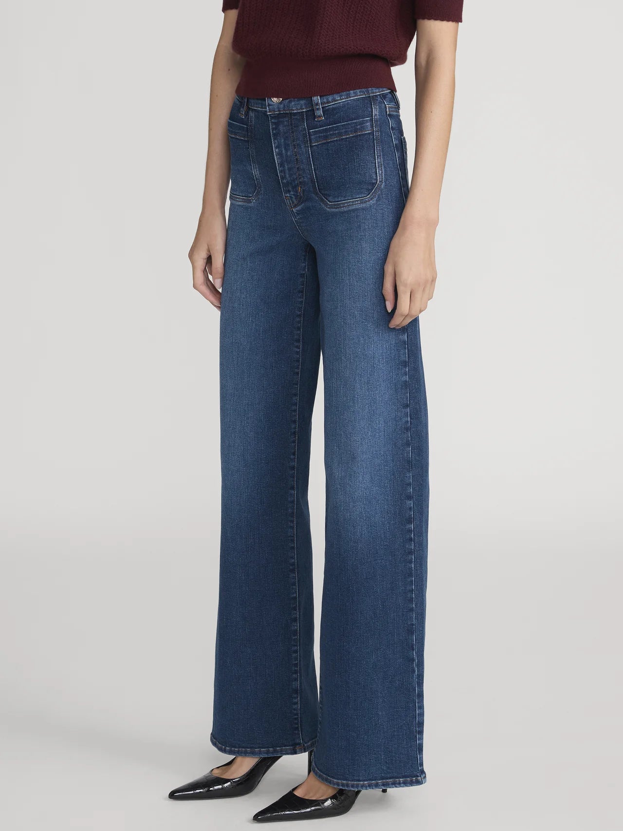 Person wearing blue jeans on a plain background