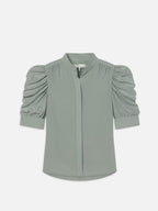 A sage green, short-sleeved, button-up shirt with ruffled detailing at the sleeves.