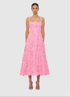 Woman wearing a pink floral dress on a light gray background