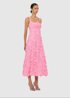 Woman wearing a pink floral dress on a light gray background