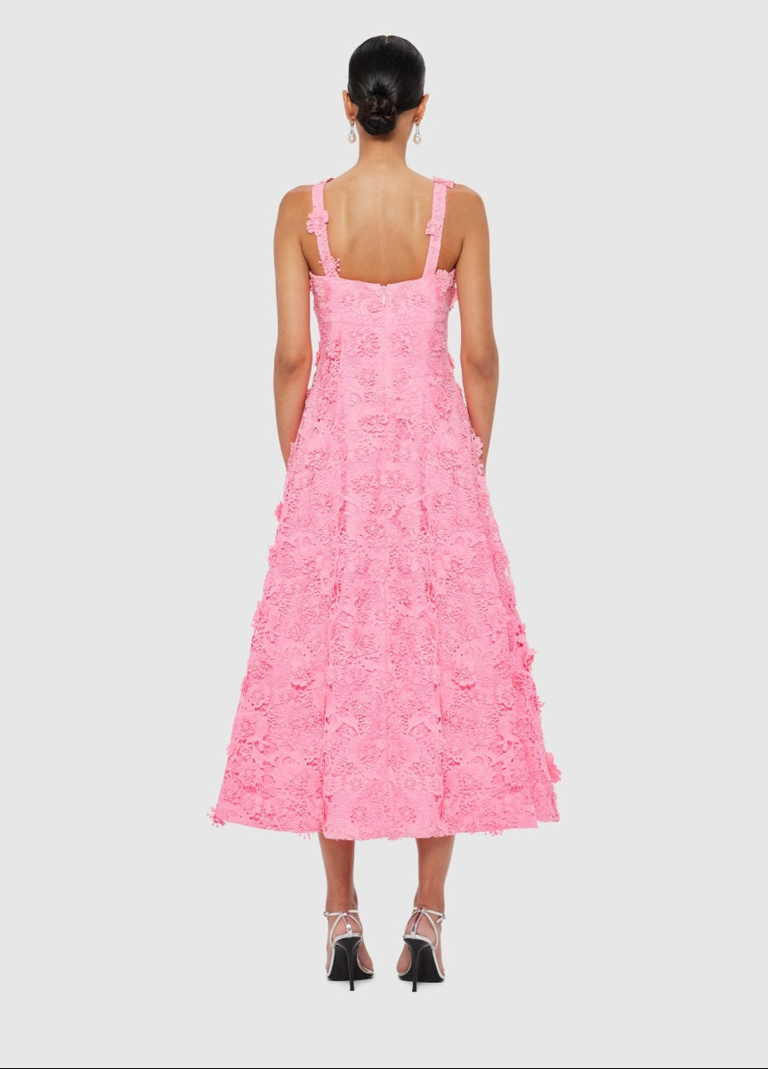 Woman wearing a pink dress with floral patterns on a light gray background