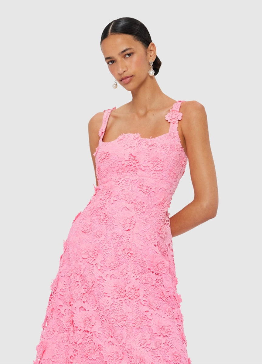 Woman wearing a pink lace dress on a light gray background