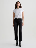 Woman wearing a white t-shirt and black jeans on a light gray background