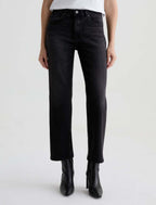 Person wearing black jeans and black boots on a white background