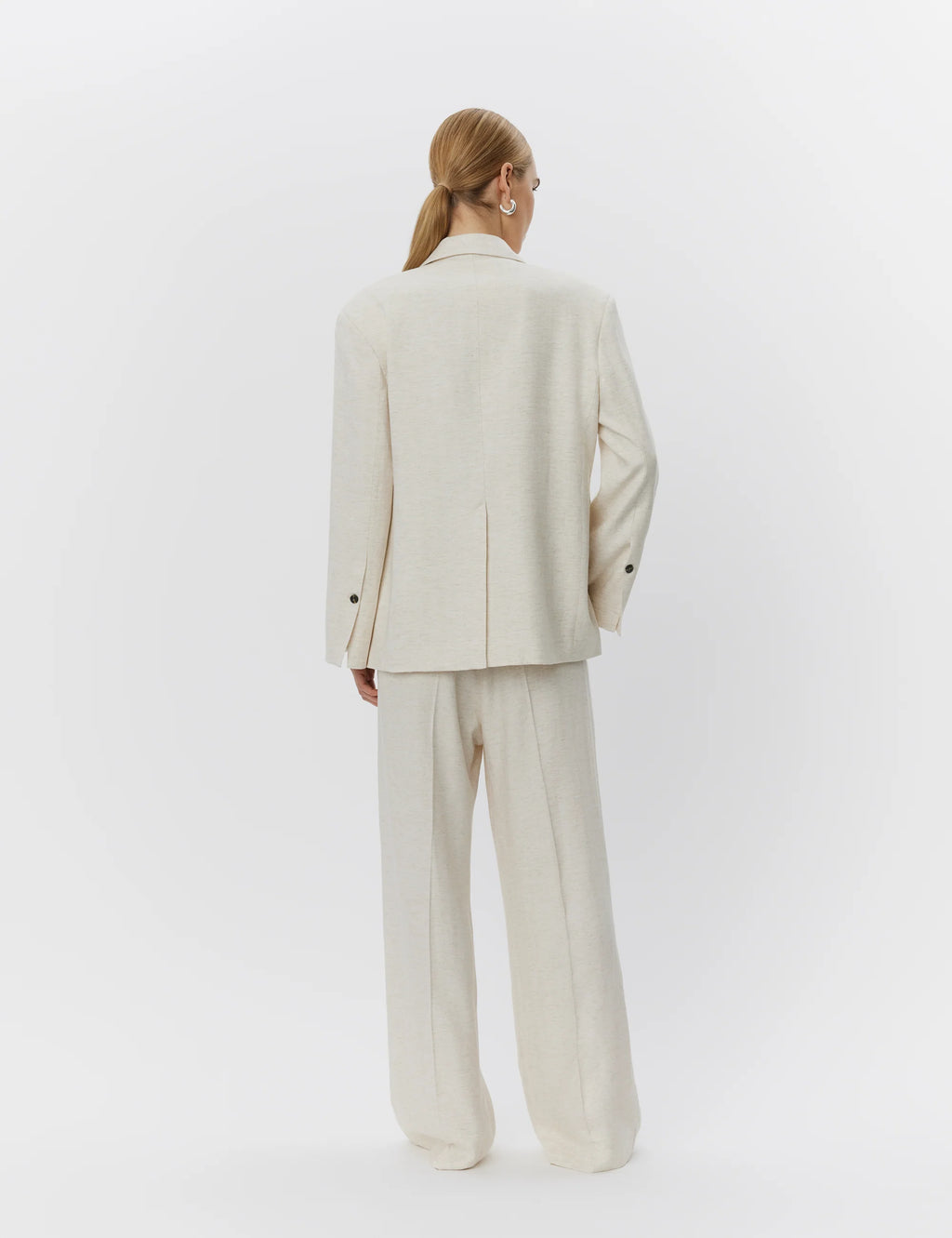 Person wearing a beige suit on a white background