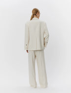 Person wearing a beige suit on a white background