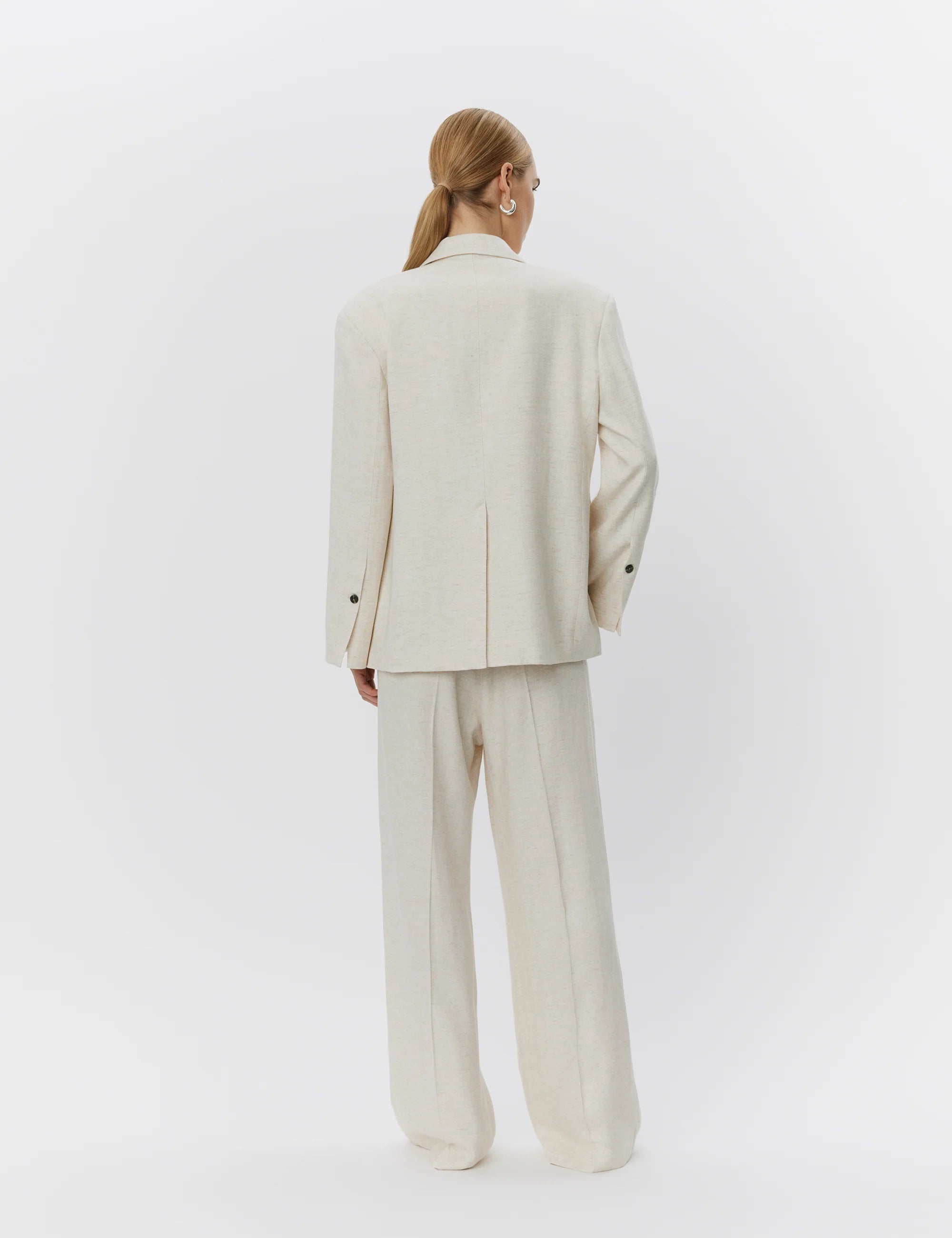 Person wearing a beige suit on a white background