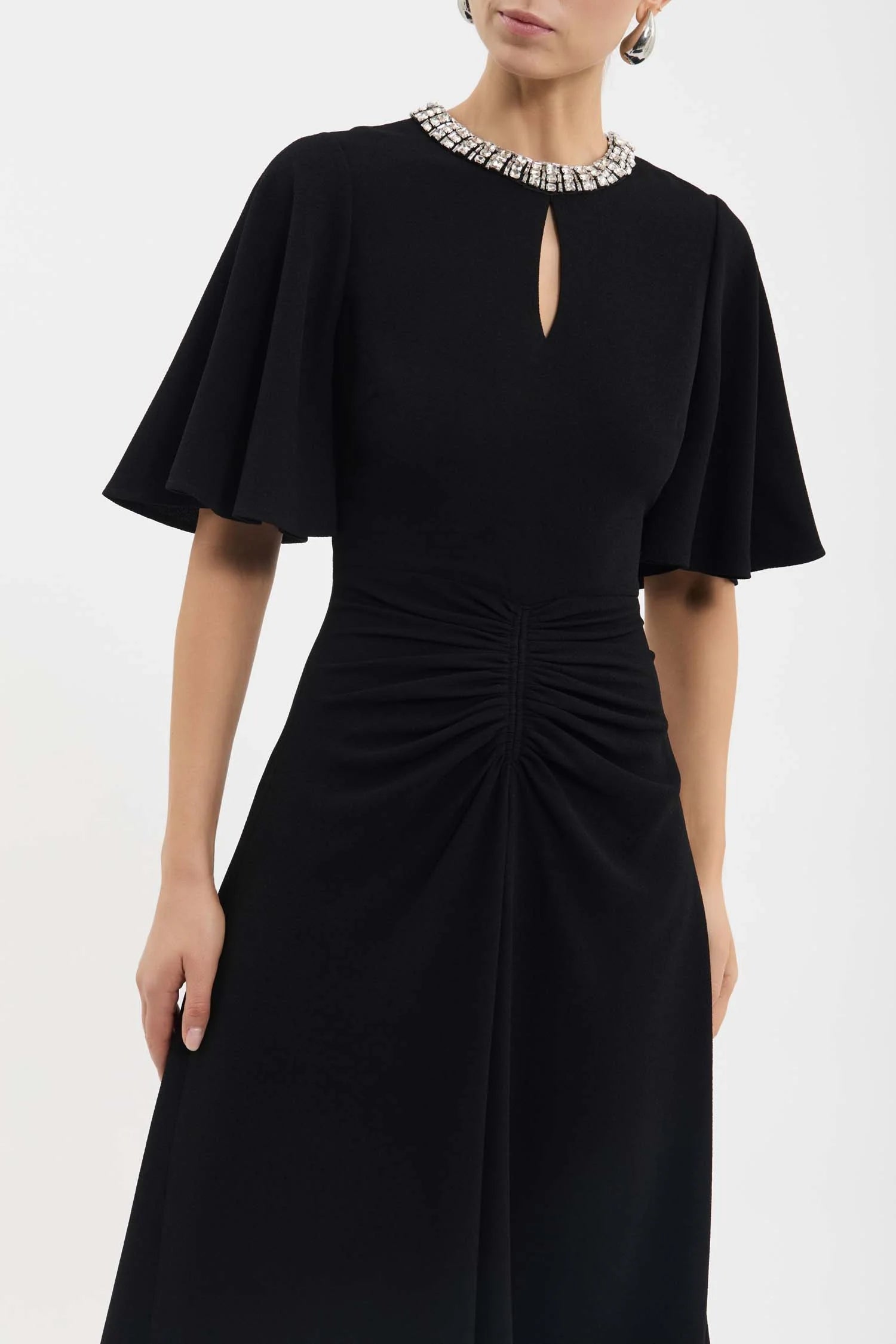 Black dress with short sleeves and a subtle cutout detail on a white background