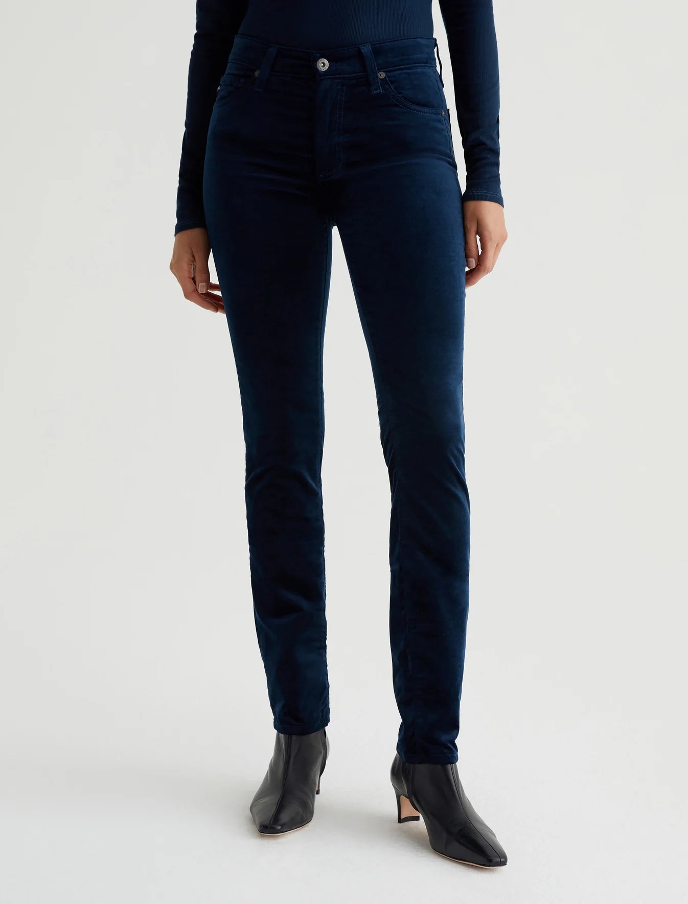 A pair of high-waisted, extended velvet blue jeans with a slim fit and straight legs.