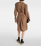 Person wearing a brown dress with a belt on a white background