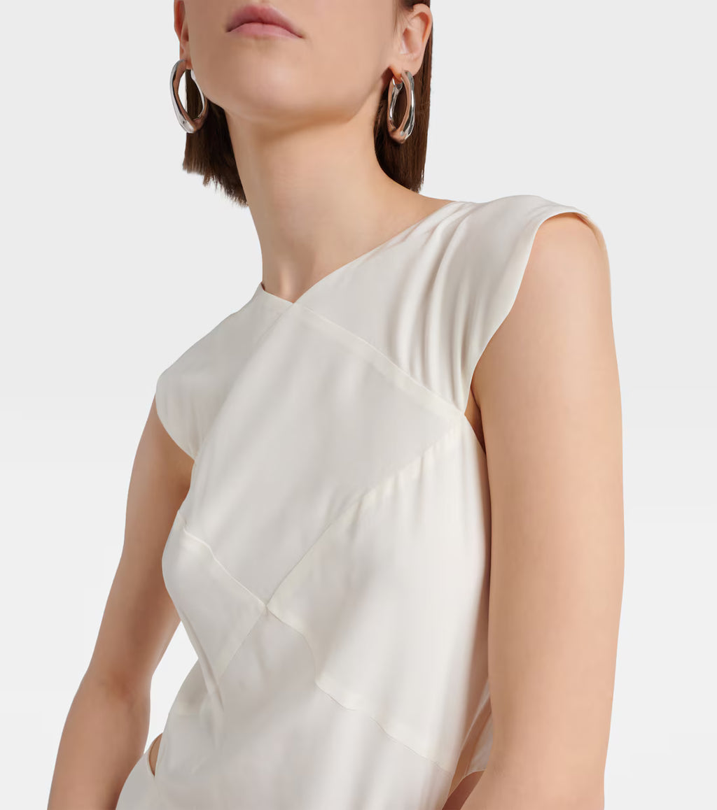 Woman wearing a white sleeveless dress with a plain background