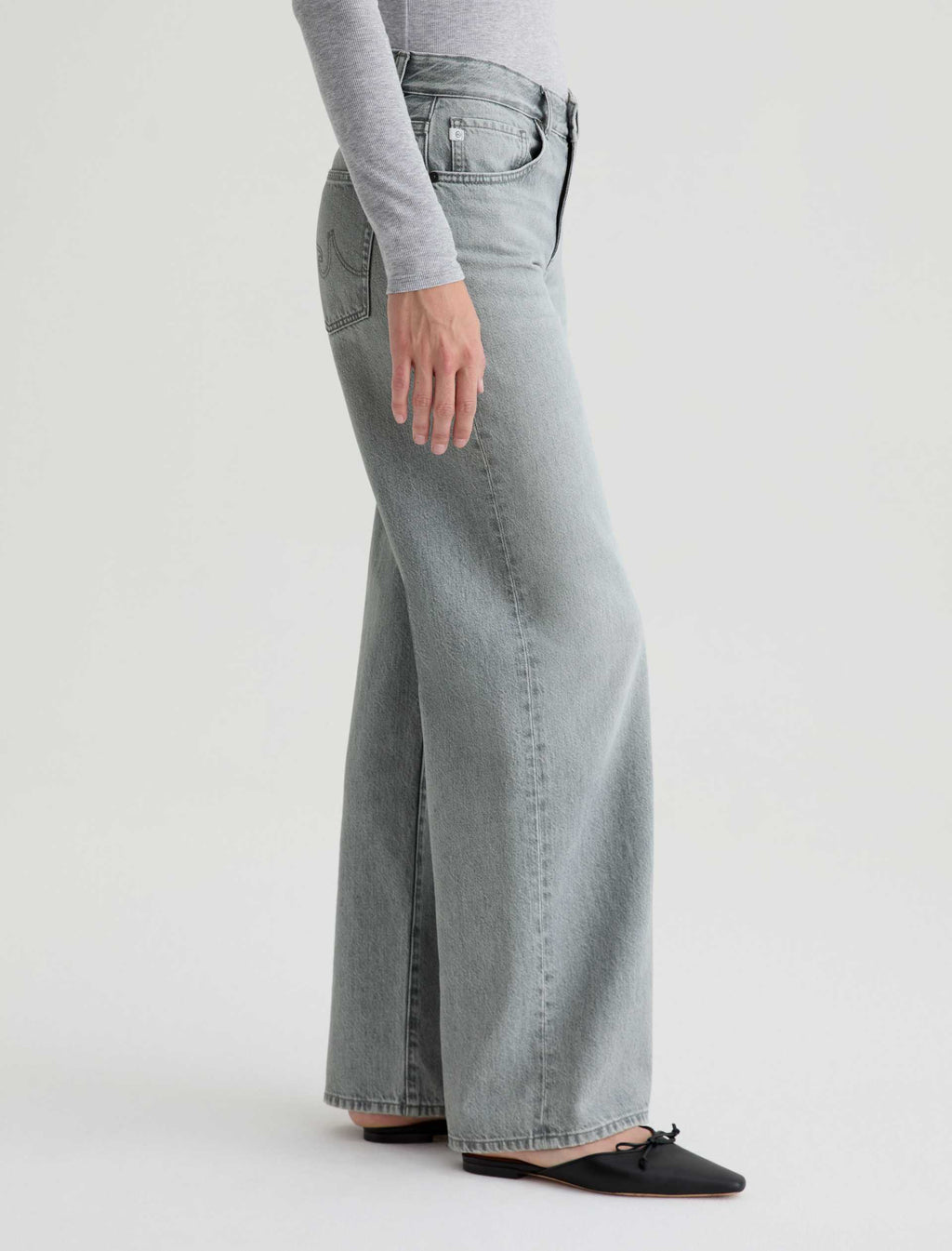 Person wearing light blue wide-leg jeans on a white background