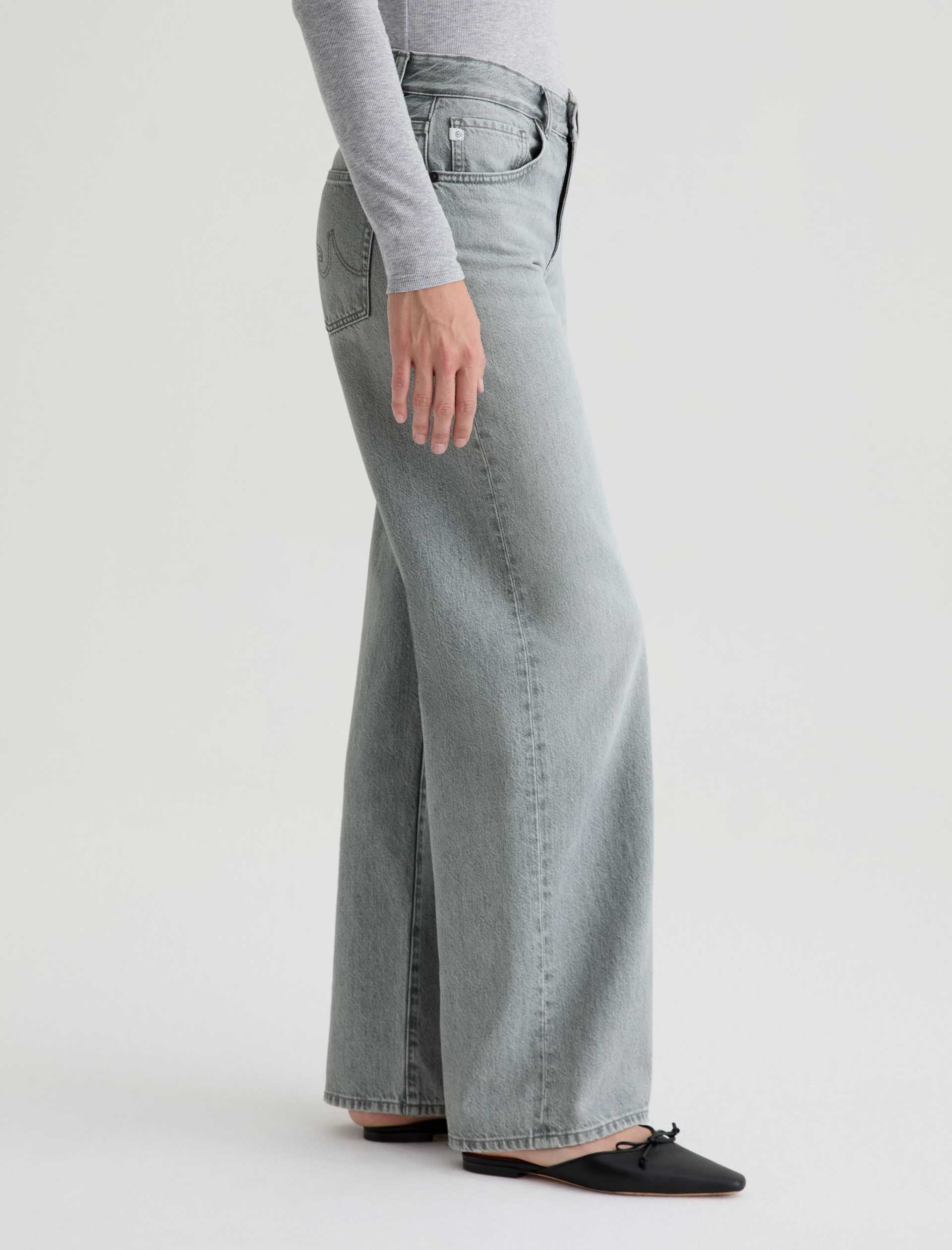 Person wearing light blue wide-leg jeans on a white background