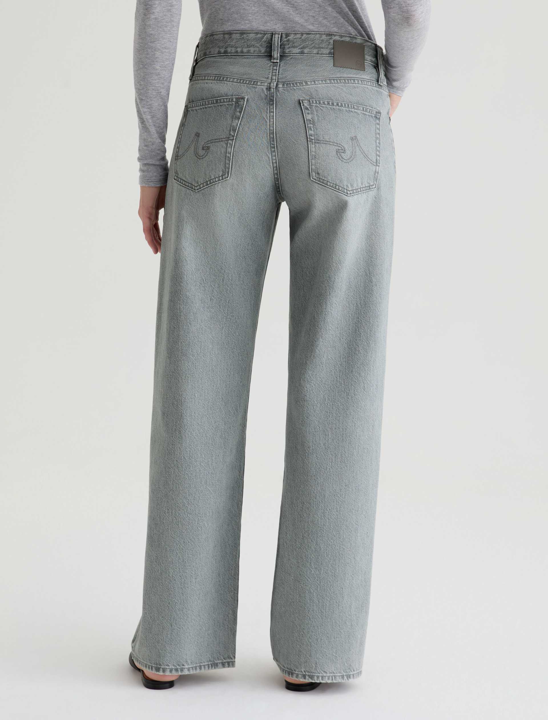 Person wearing light blue jeans on a white background