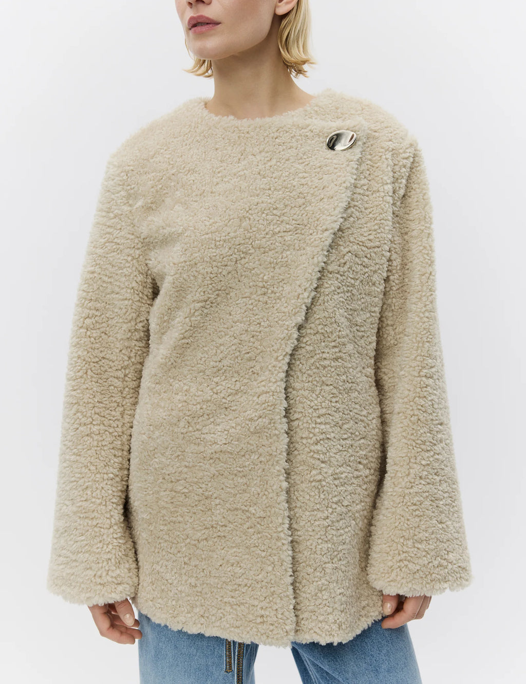 Person wearing a beige fluffy sweater on a white background