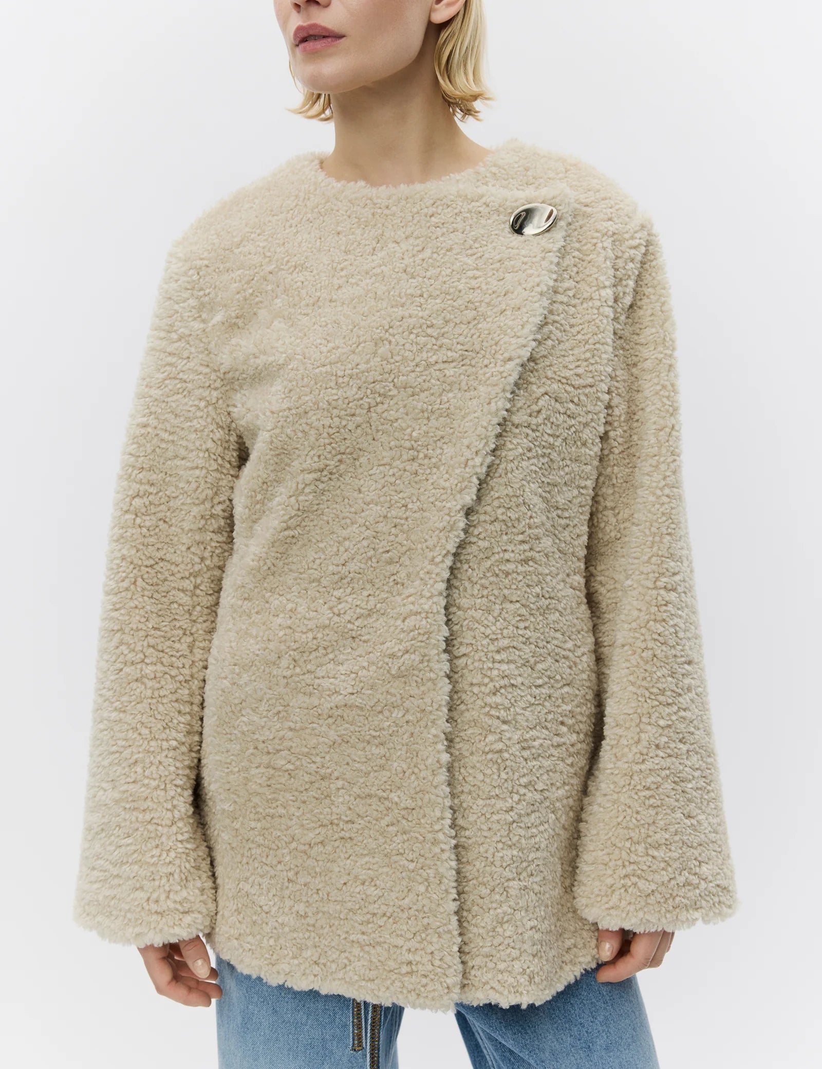 Person wearing a beige fluffy sweater on a white background