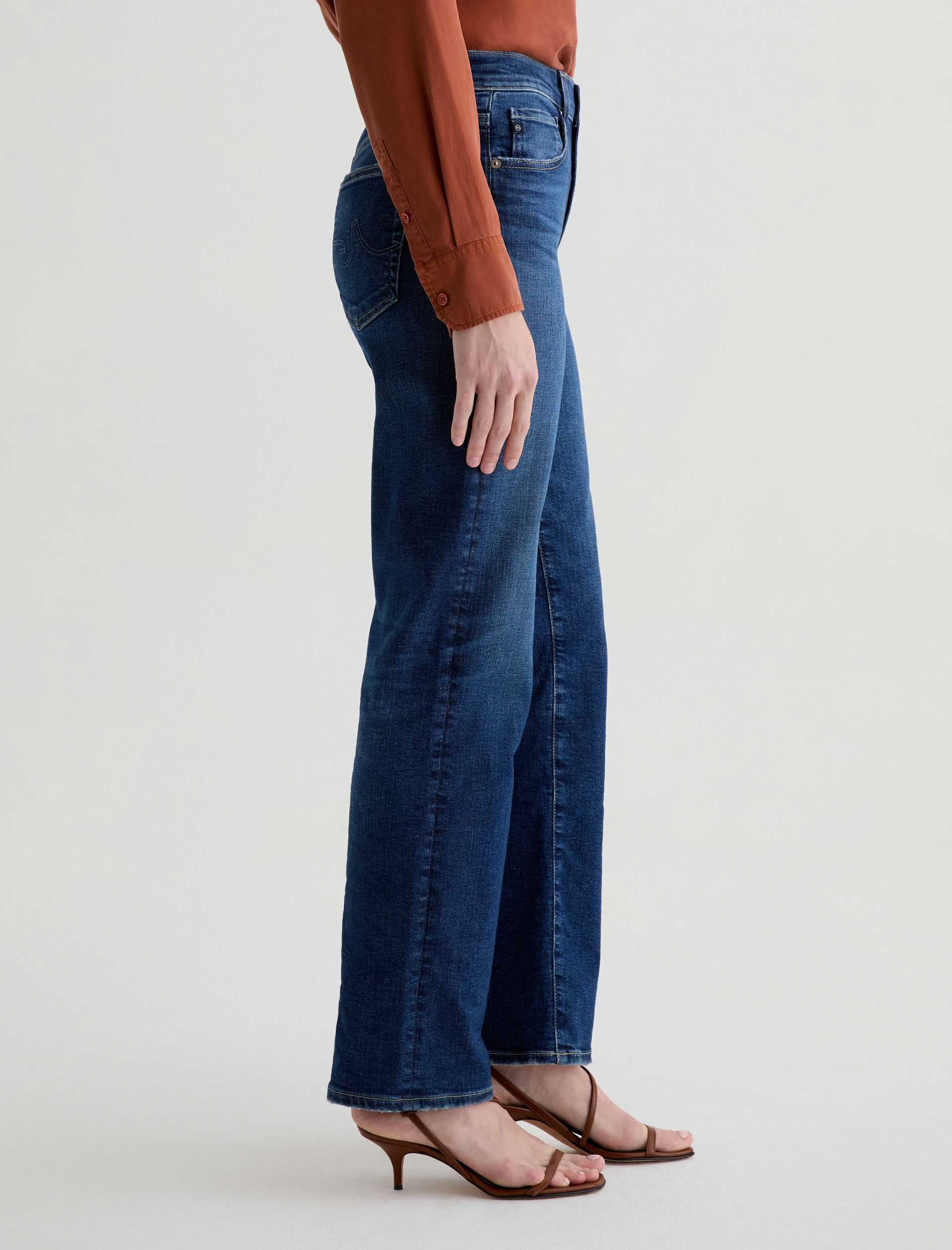 Person wearing blue jeans on a plain background