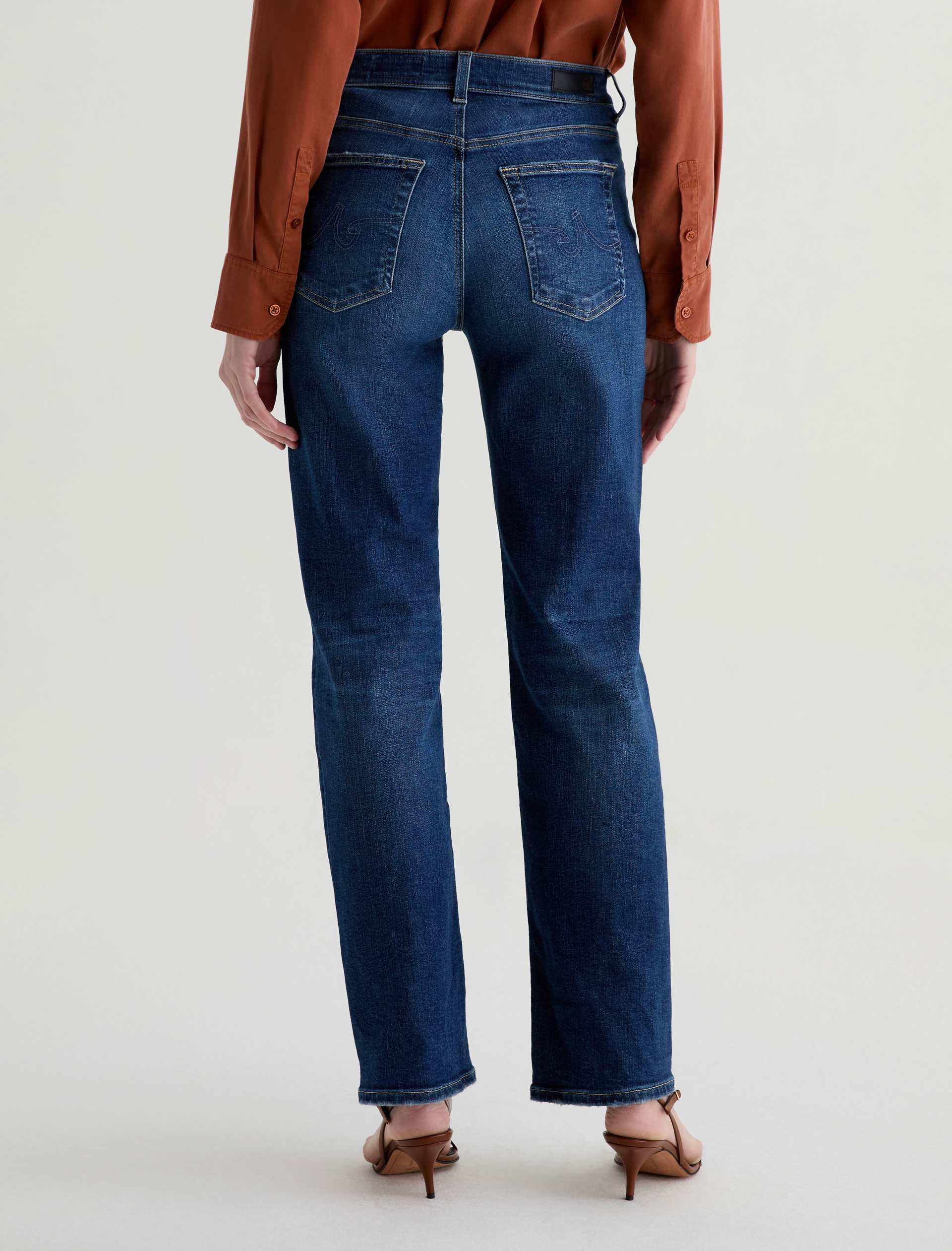 Person wearing blue jeans on a plain background
