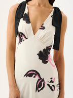 White dress with black and pink floral patterns and black bows on shoulders against a white background