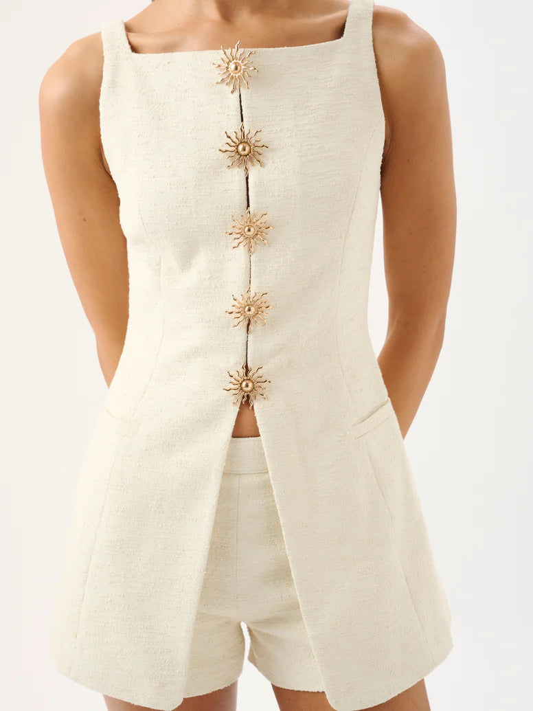 Beige sleeveless top with floral buttons and matching shorts on a white background