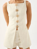 Beige sleeveless top with floral buttons and matching shorts on a white background