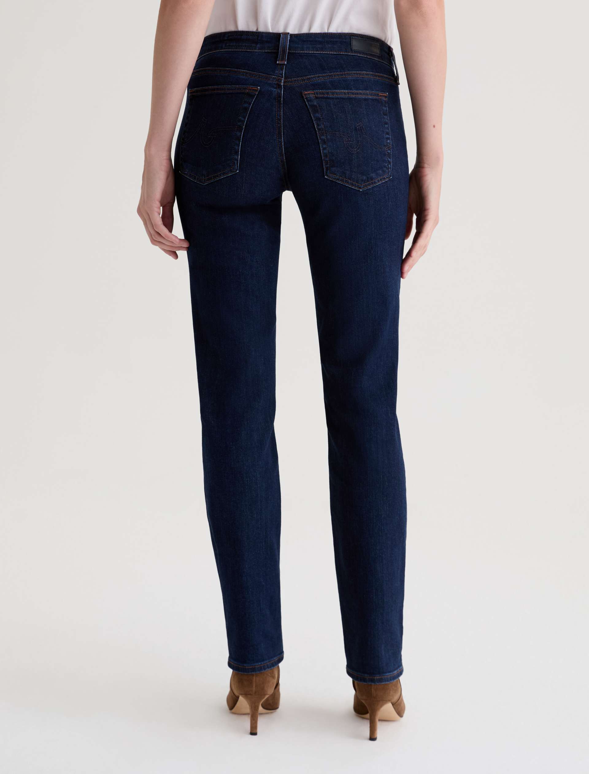 Person wearing dark blue jeans on a white background