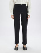 Person wearing black pants and a white sweater on a white background