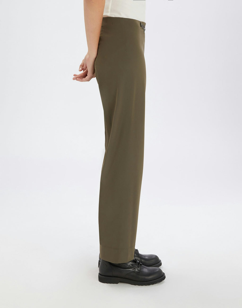 Person wearing olive green pants on a white background