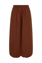 A pair of wide-leg cropped pants in a solid rust brown color, featuring an elastic waistband, shown against a plain white background.