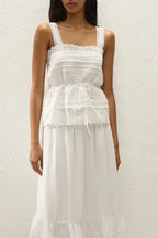 Woman wearing a white lace dress against a plain background