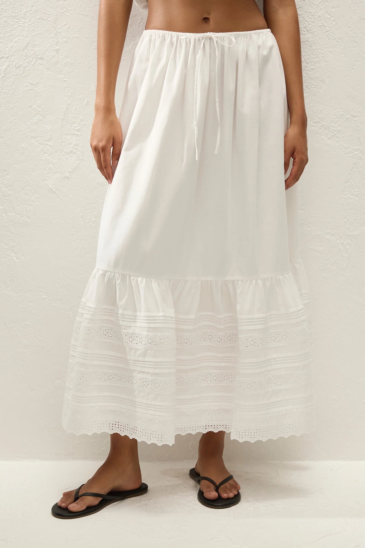White tiered skirt worn by a person on a white background