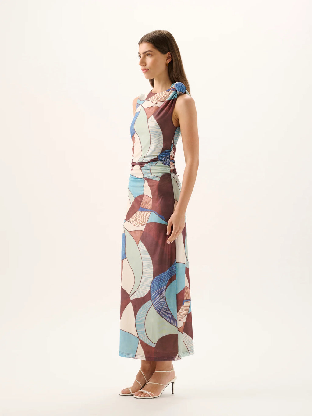 Woman wearing a colorful patterned dress on a white background