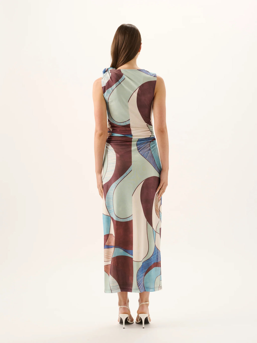 Woman wearing a sleeveless dress with abstract pattern on a white background