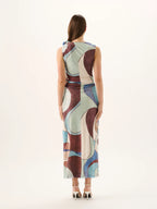 Woman wearing a sleeveless dress with abstract pattern on a white background