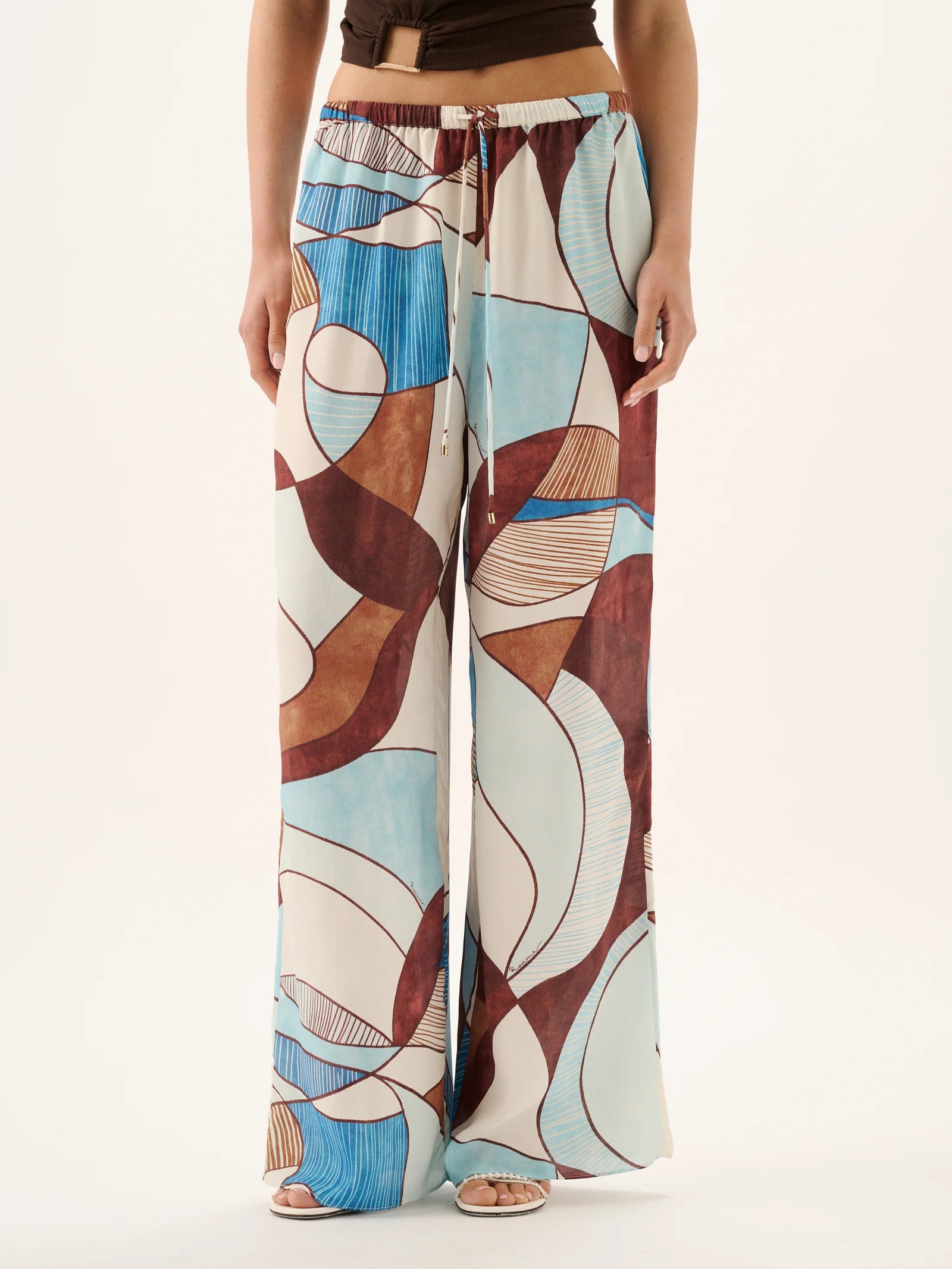 Colorful patterned pants worn by a person on a white background