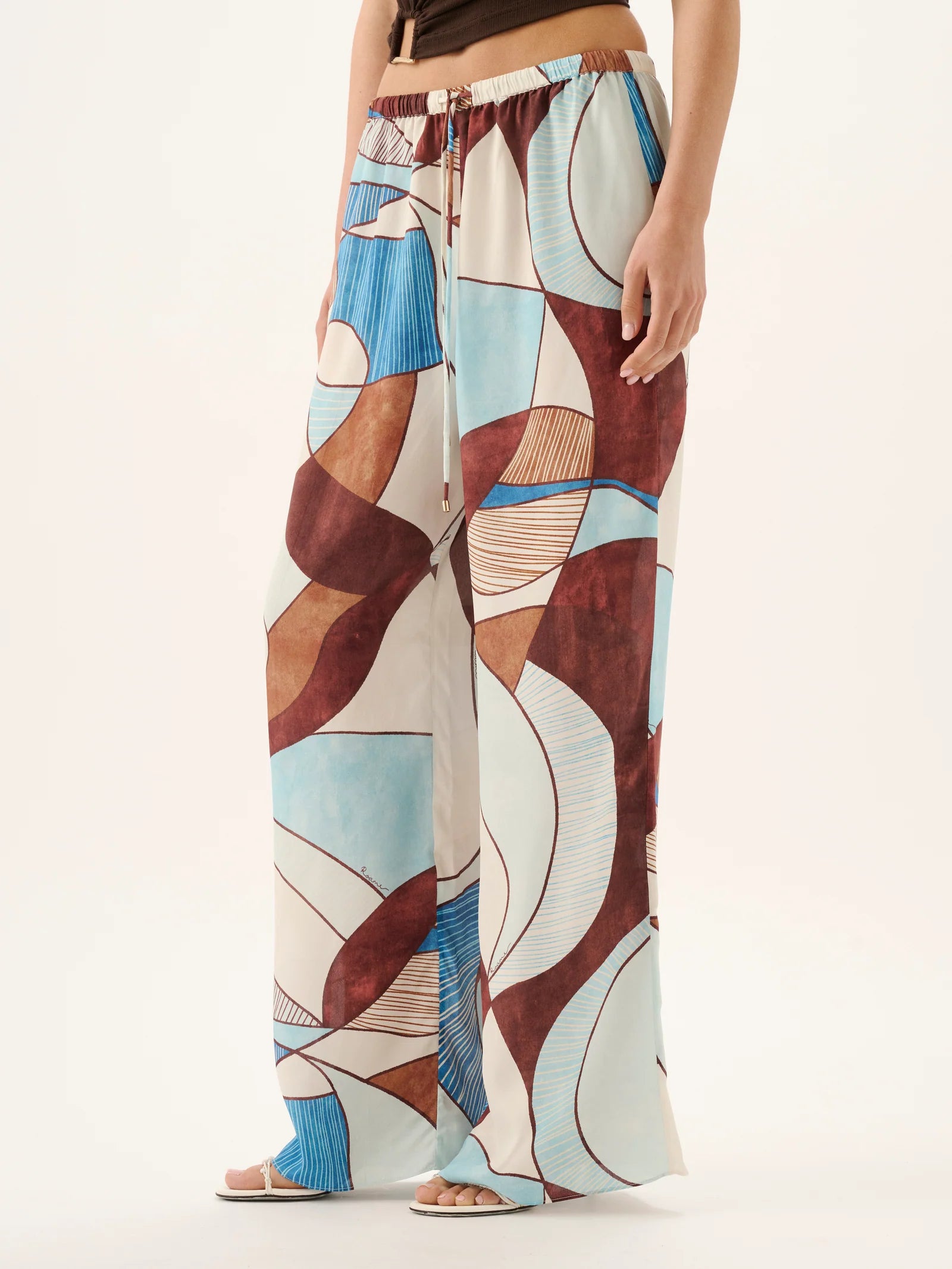 Colorful patterned pants worn by a person on a white background