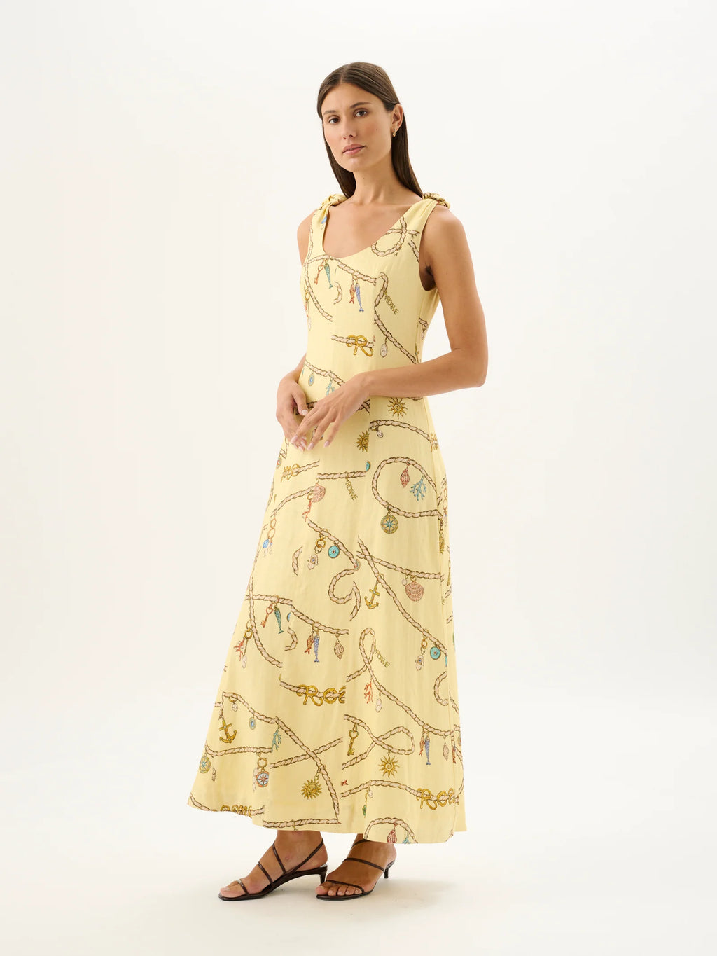 Woman wearing a yellow dress with a pattern on a white background