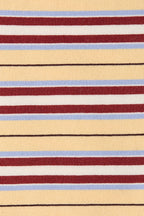A close-up of a striped woven fabric with horizontal bands of pale yellow, burgundy red, white, light blue, and thin black lines.
