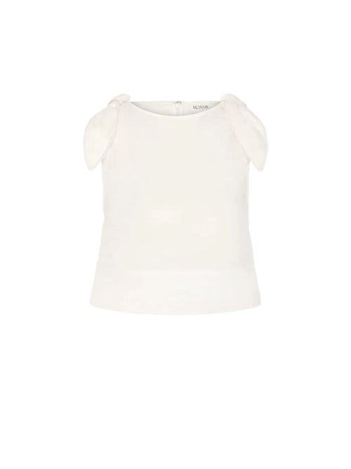 An off-white sleeveless top with delicate shoulder tie details, displayed against a solid light gray background.