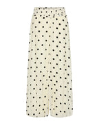 A pair of wide-leg cropped pants in a cream-colored fabric with a black polka dot pattern, shown against a light gray background.