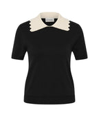 A black short-sleeve knit top with a contrasting cream-colored pointed collar, shown on a light gray background.