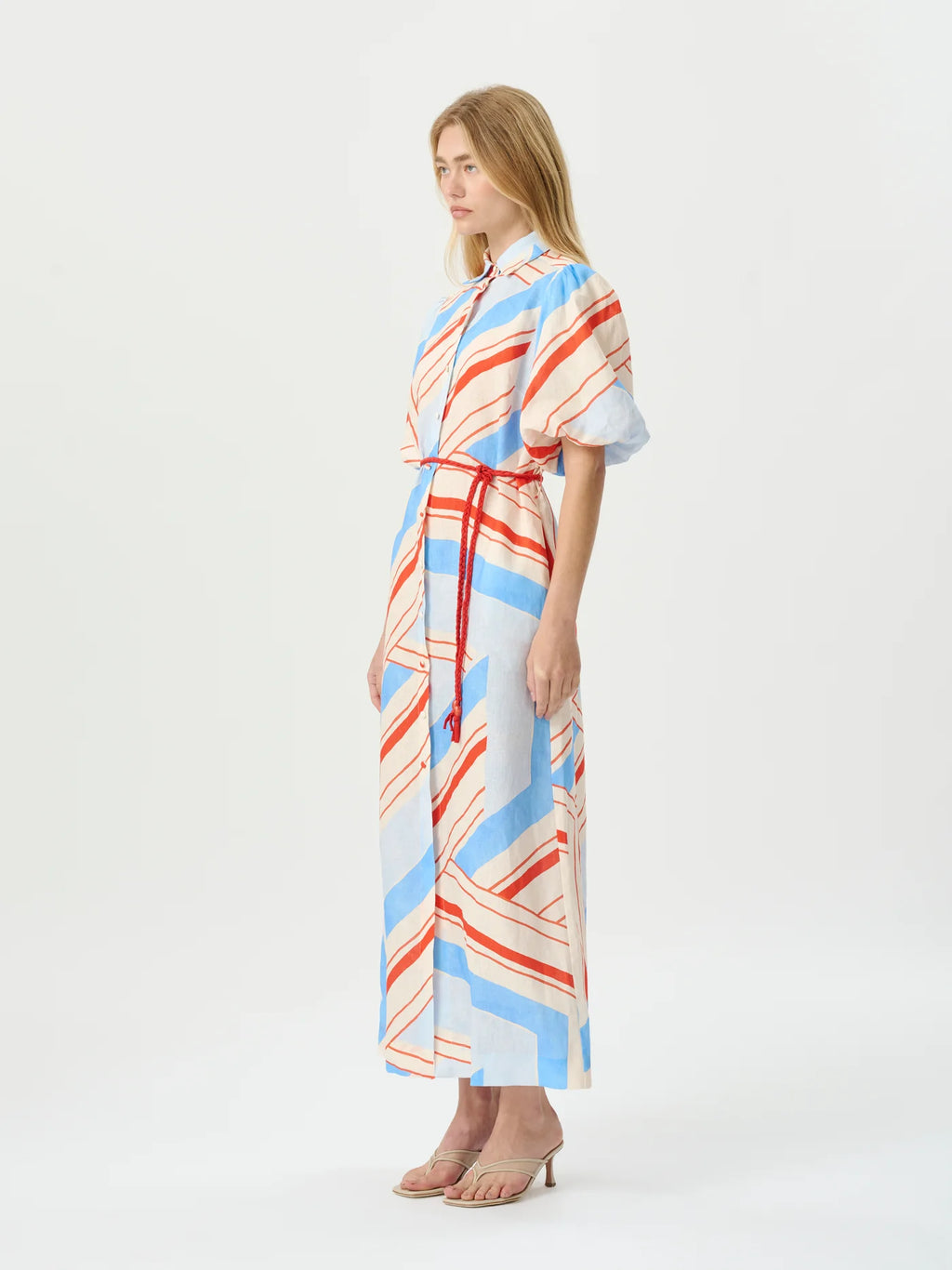 Woman wearing a colorful striped dress on a white background