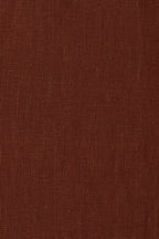 A close-up of a textured brown fabric surface with a fine woven pattern.