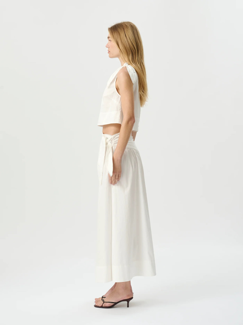 Woman wearing a white outfit on a plain background